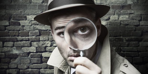 Detektiv schaut durch eine Lupe, schwarz-weiß